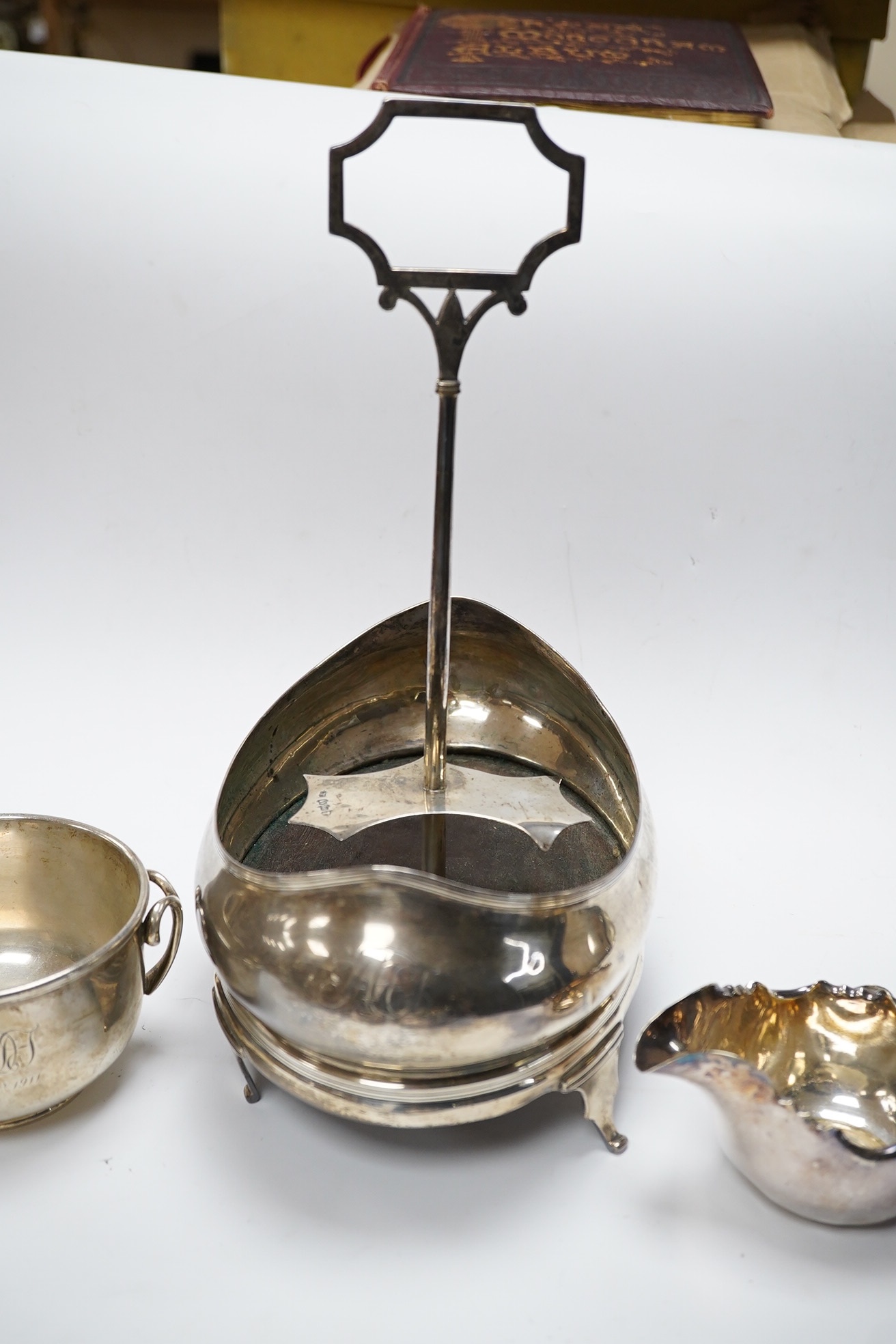 A George III silver oval cruet stand, London, 1804, (lacking bottles), height 28.7cm, together with two silver bowls, one two handled by Mappin & Webb, London, 1911 and a plated bowl and jug. Condition - poor to fair.